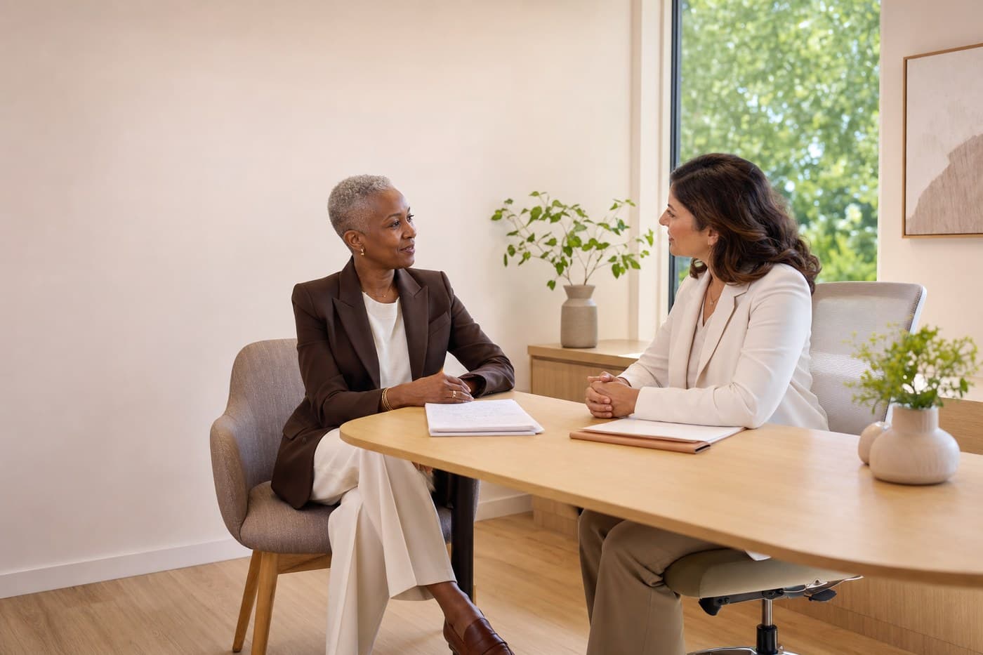 A woman in her fifties in a consulting room with written notes, talking with a doctor.